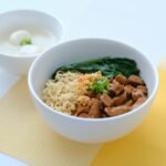 A delicious noodle bowl with beef, spinach, and eggs, perfect for a satisfying meal.
